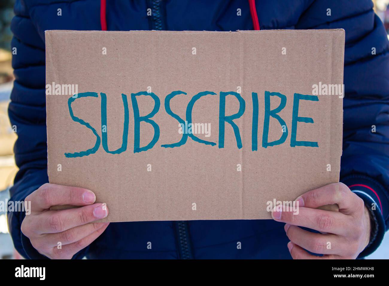 Man holding cardboard box with subscribe word. Stock Photo