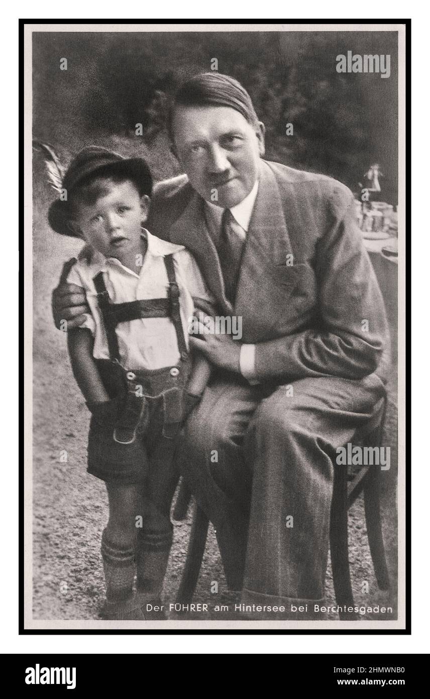 1930s Adolf Hitler 'The guide at the Hintersee near Berchtesgaden' Nazi Propaganda image of Adolf Hitler being a politician and hugging a small (Aryan) boy child Gerhard Bartels, (leaning away from Hitler) being used for Nazi propaganda. With his blue eyes, fair hair and Aryan features Gerhard Bartels was the perfect Nazi poster child. And, because his uncle was a friend of Adolf Hitler, being pictured with the dictator became for him an unpopular uncomfortable annual event. Stock Photo
