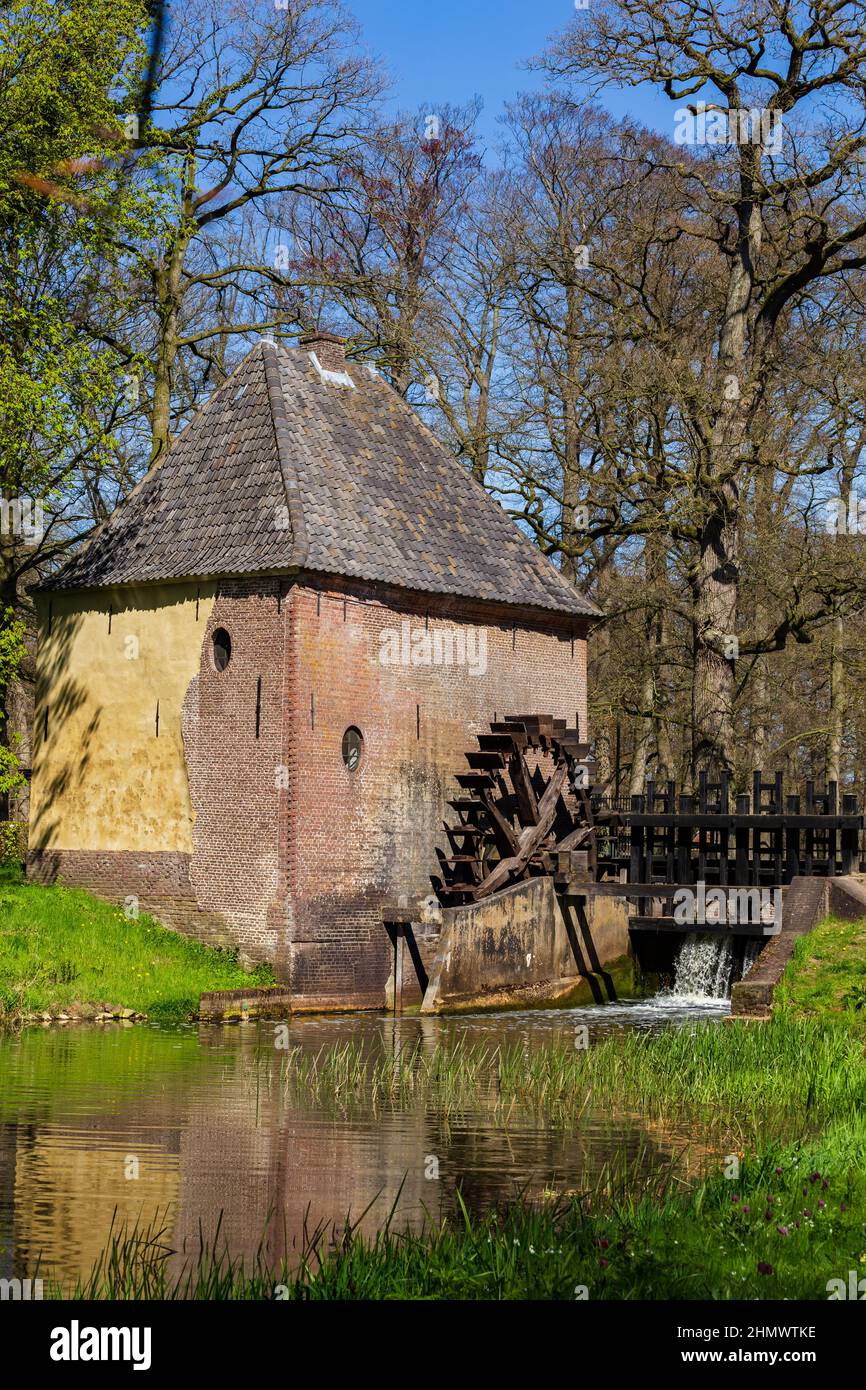 Vorden, The Netherlands - April 26, 2021: Watermill in park Hackfort in Vorden Gelderland in The Netherlands famous for his beautiful wild flowers Stock Photo