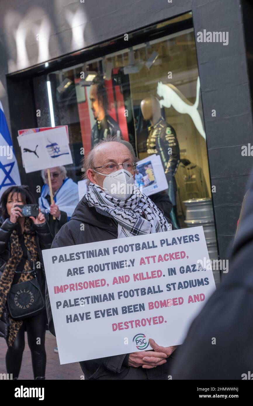 London, UK. 12th Feb 2022. Protesters at Puma's flagship Carnaby St store support over 200 Palestinian sports teams who demand that PUMA end its sponsorship of the Israeli Football Association which includes teams in illegal Israeli settlements on stolen Palestinian land. The protest, part of a day of over 25 similar UK actions by the Palestinian Solidarity Campaign UK, was opposed by a small group with Israel flags who shouted at them. Peter Marshall/Alamy Live News Stock Photo