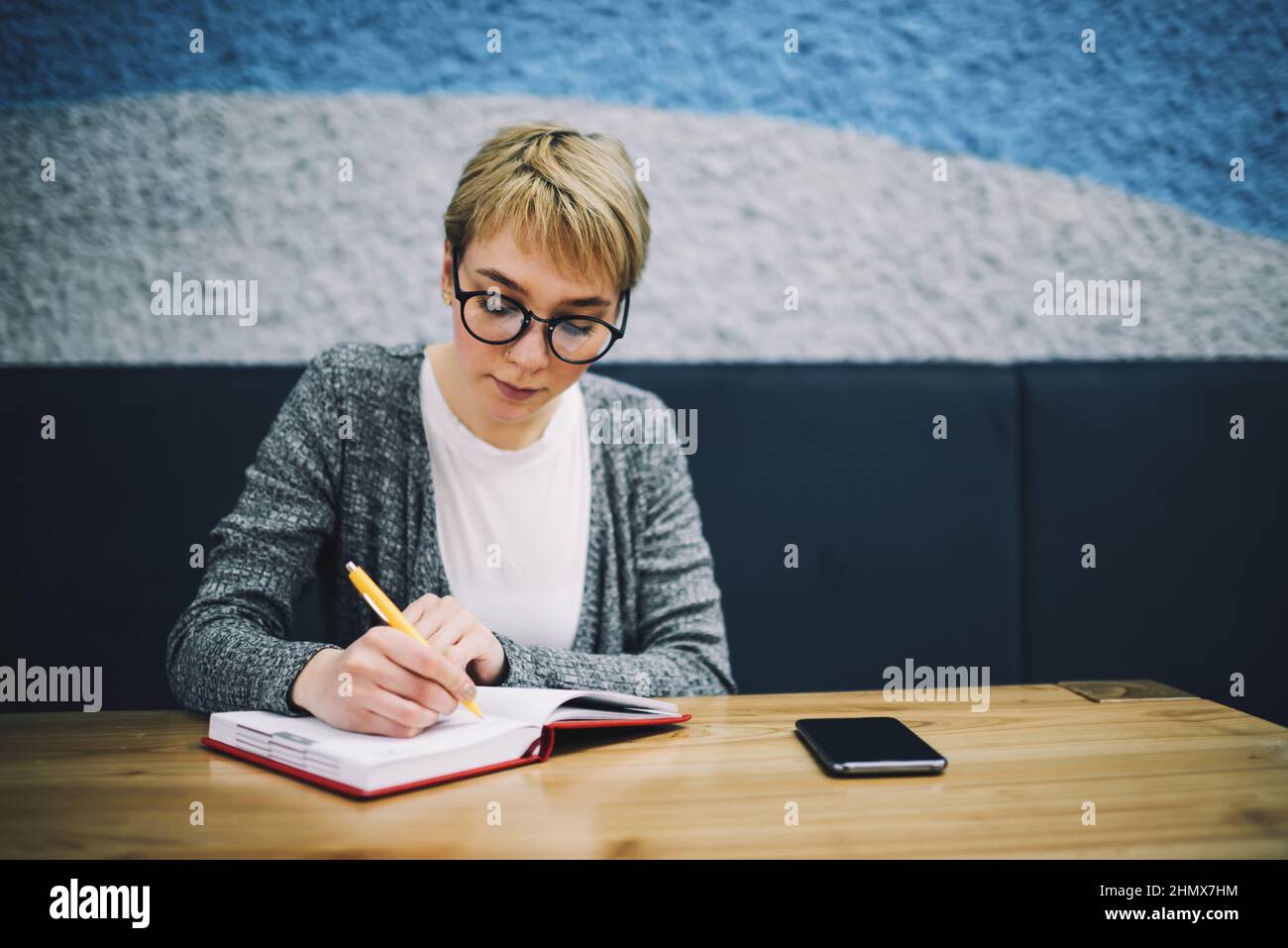 Serious woman writing ideas for project Stock Photo