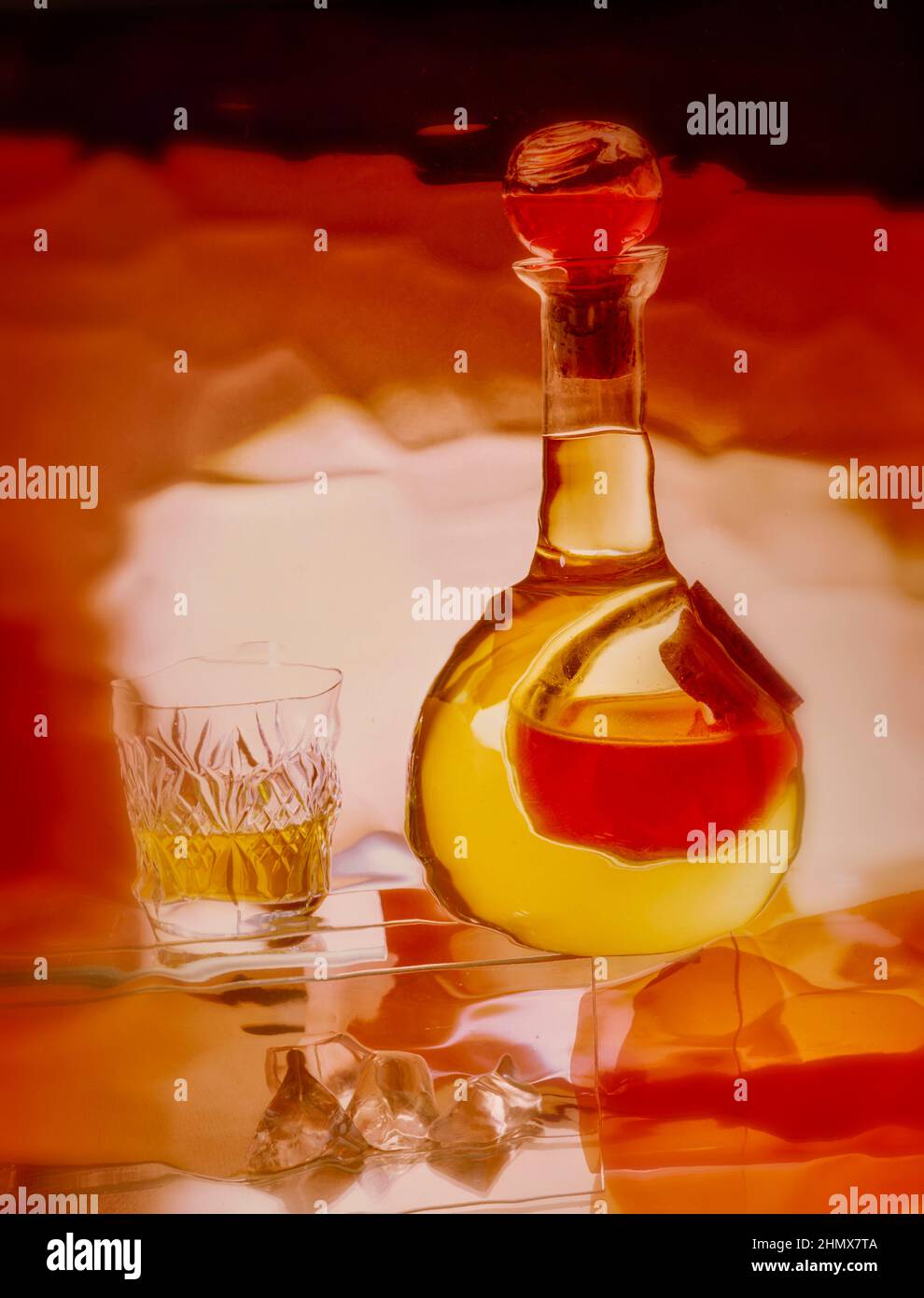 Creative abstract still-life of glass bottle with colour, and a cut crystal glass Stock Photo