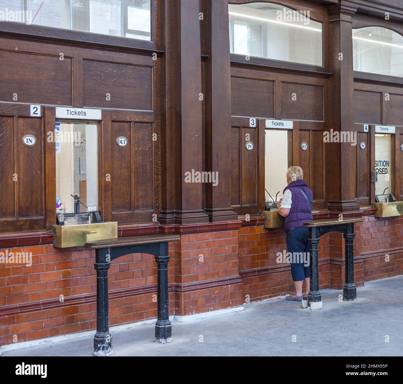 Rail passenger buying rail tickets at Manchester Victoria railway