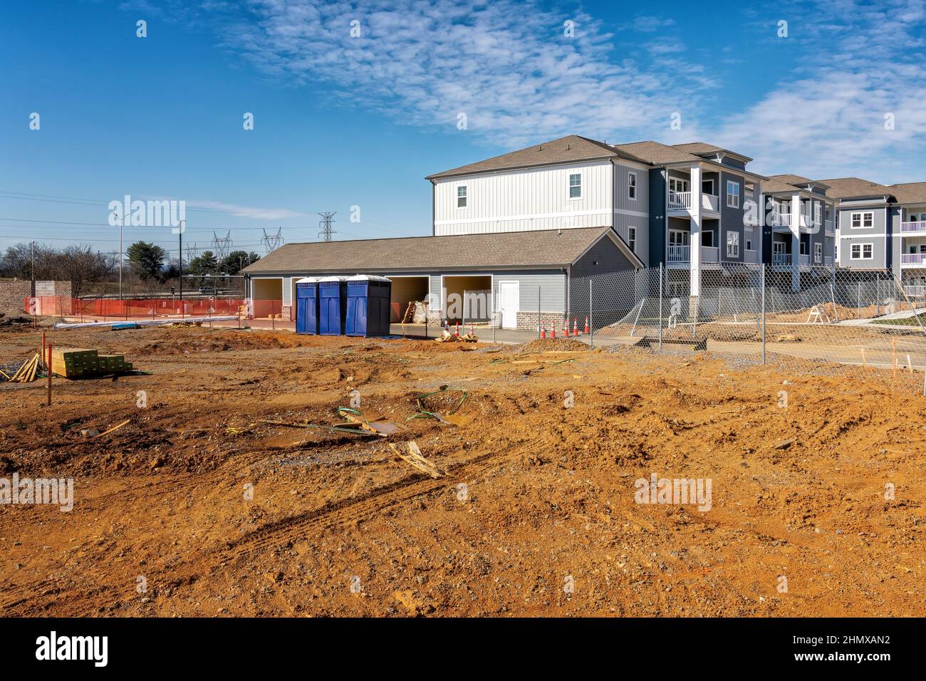 Horizontal shot of an apartment complext construction site with porta potties or portable toilets. Stock Photo