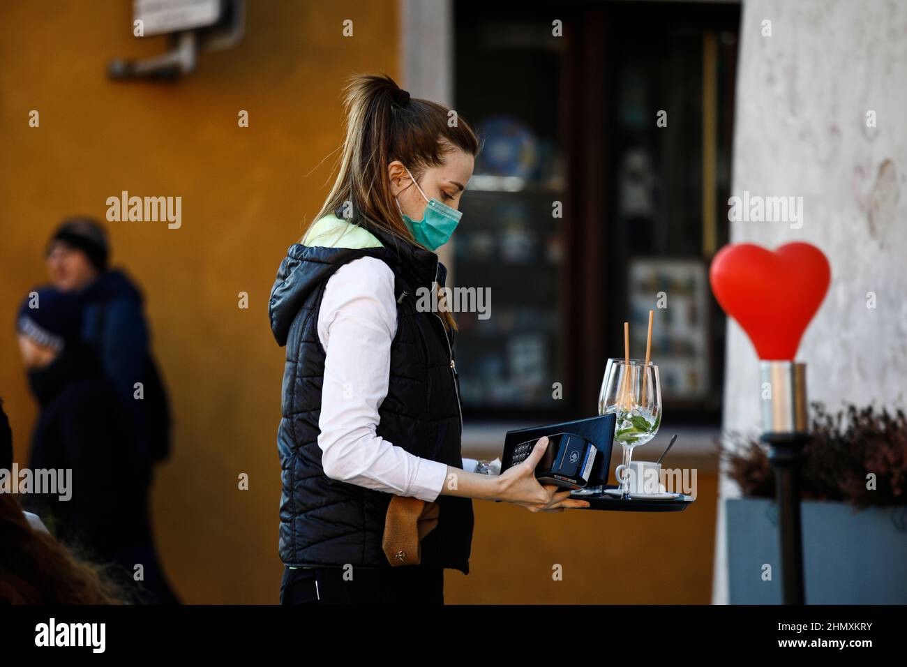 A waiter wearing a face mask is seen in the Old Town of Warsaw, Poland on 12 February, 2022. Minister of Health Adam Niedzielski this week announced t Stock Photo