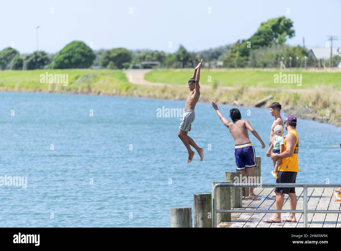 Opotiki New Zealand - January 30 2022; Young people jumping into Otara River enjoying summer fun Stock Photo