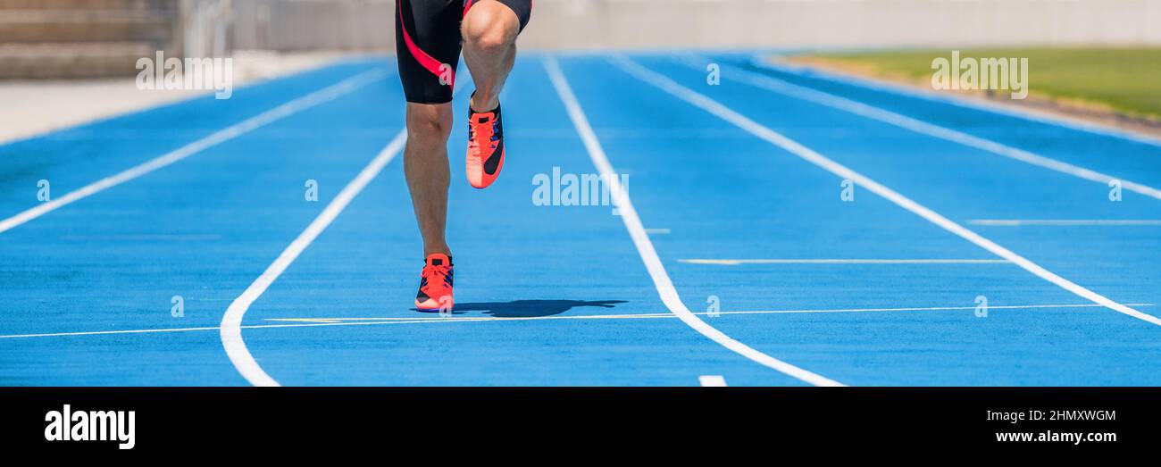 Athlete sprinter runner training sprinting dynamic run on running tracks at stadium. Panoramic banner of man legs and running shoes Stock Photo