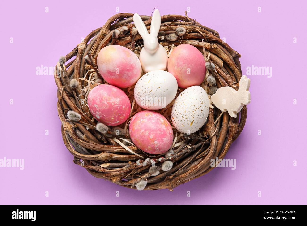 Nest with painted Easter eggs, bunny and pussy willow branches on ...