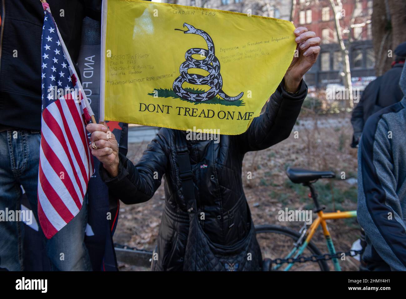 New York, NY, USA - February 11, 2022: Woman holds a Gadsden flag that reads 'Dont Tread On Me' at a demonstration to protest New York City’s vaccine Stock Photo