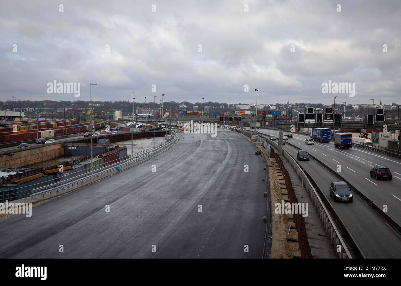 11 February 2022, Hamburg: Traffic flows on various lanes of the A7 freeway south of the Elbe Tunnel next to the carriageway of the new K30 West embankment (l). Due to construction work south of the Elbe Tunnel, the A7 will be fully closed from Feb. 18 (10 p.m.) to Feb. 21 (5 a.m.) between the Hamburg-Volkspark and -Heimfeld interchanges. During the weekend, all six lanes are to be transferred to the new embankment structure. Construction of the other half of the ramp, the new link between the Elbe Tunnel and the Elbmarsch elevated highway, can then begin. At around four kilometers in length, Stock Photo
