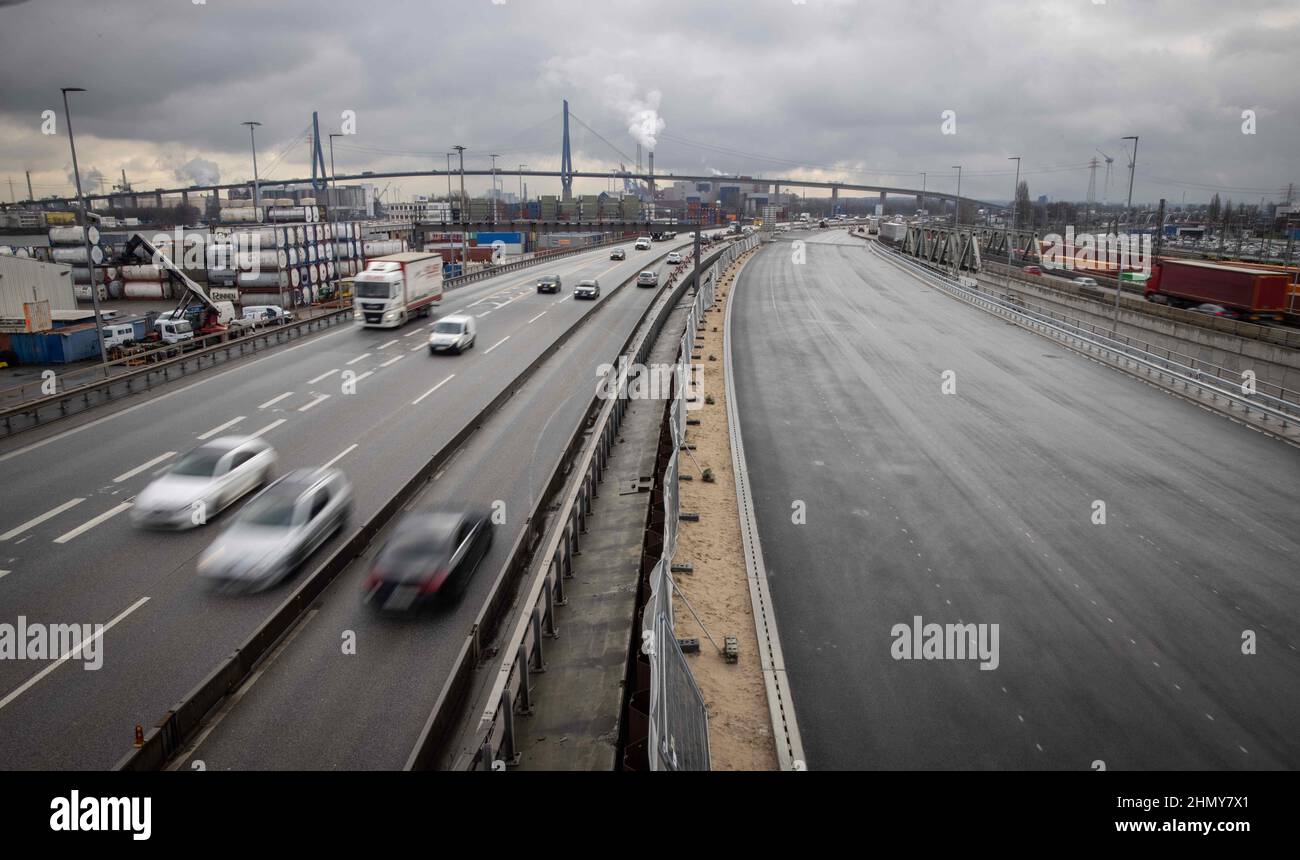 11 February 2022, Hamburg: Traffic flows on various lanes of the A7 freeway south of the Elbe Tunnel next to the carriageway of the new K30 West embankment (r). Due to construction work south of the Elbe Tunnel, the A7 will be fully closed from Feb. 18 (10 p.m.) to Feb. 21 (5 a.m.) between the Hamburg-Volkspark and -Heimfeld interchanges. During the weekend, all six lanes are to be transferred to the new embankment structure. Construction of the other half of the ramp, the new link between the Elbe Tunnel and the Elbmarsch elevated highway, can then begin. At around four kilometers in length, Stock Photo