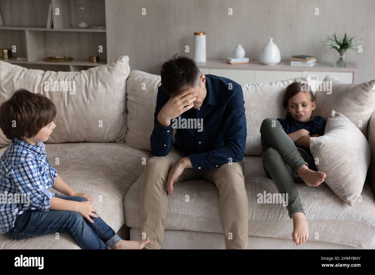 Tired dad and bored sibling kids going through conflict Stock Photo