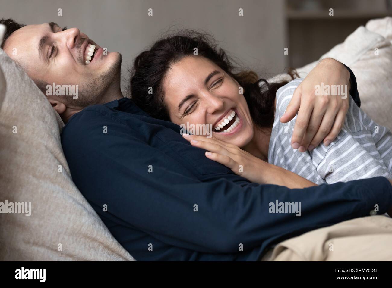 Joyful millennial couple having fun and enjoying closeness at home Stock Photo
