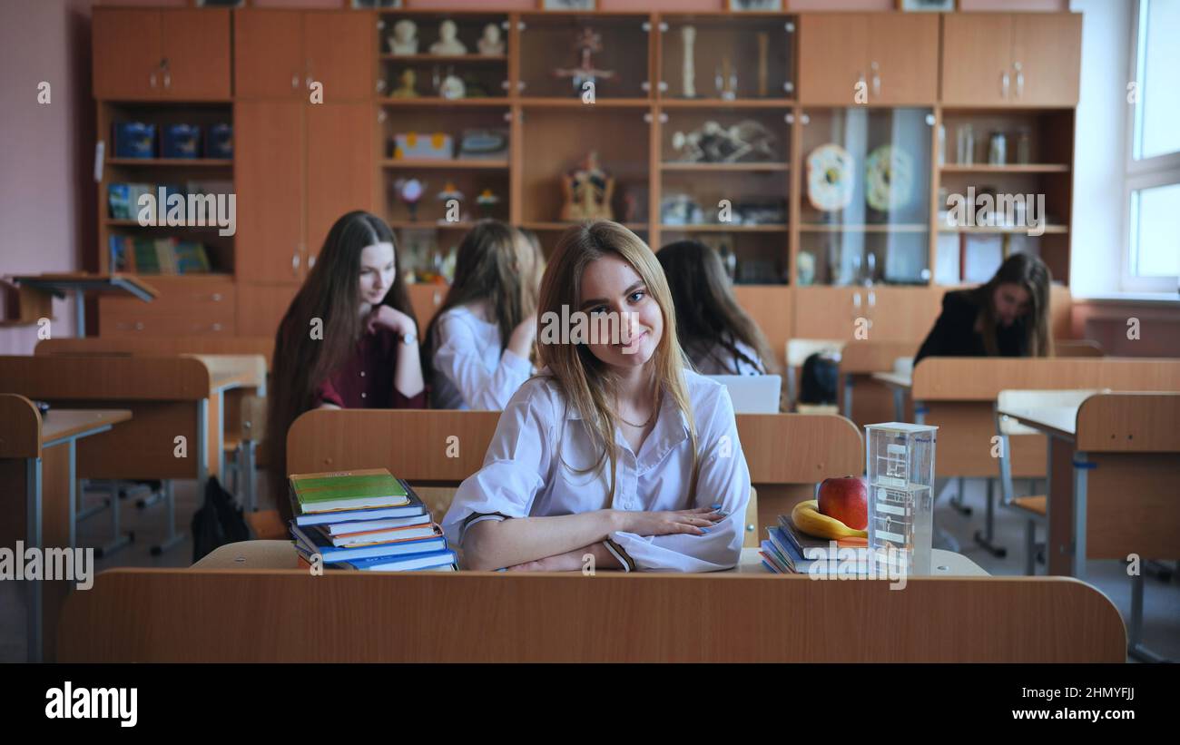 Schoolgirl poses with textbooks at her desk in her class Stock Photo ...