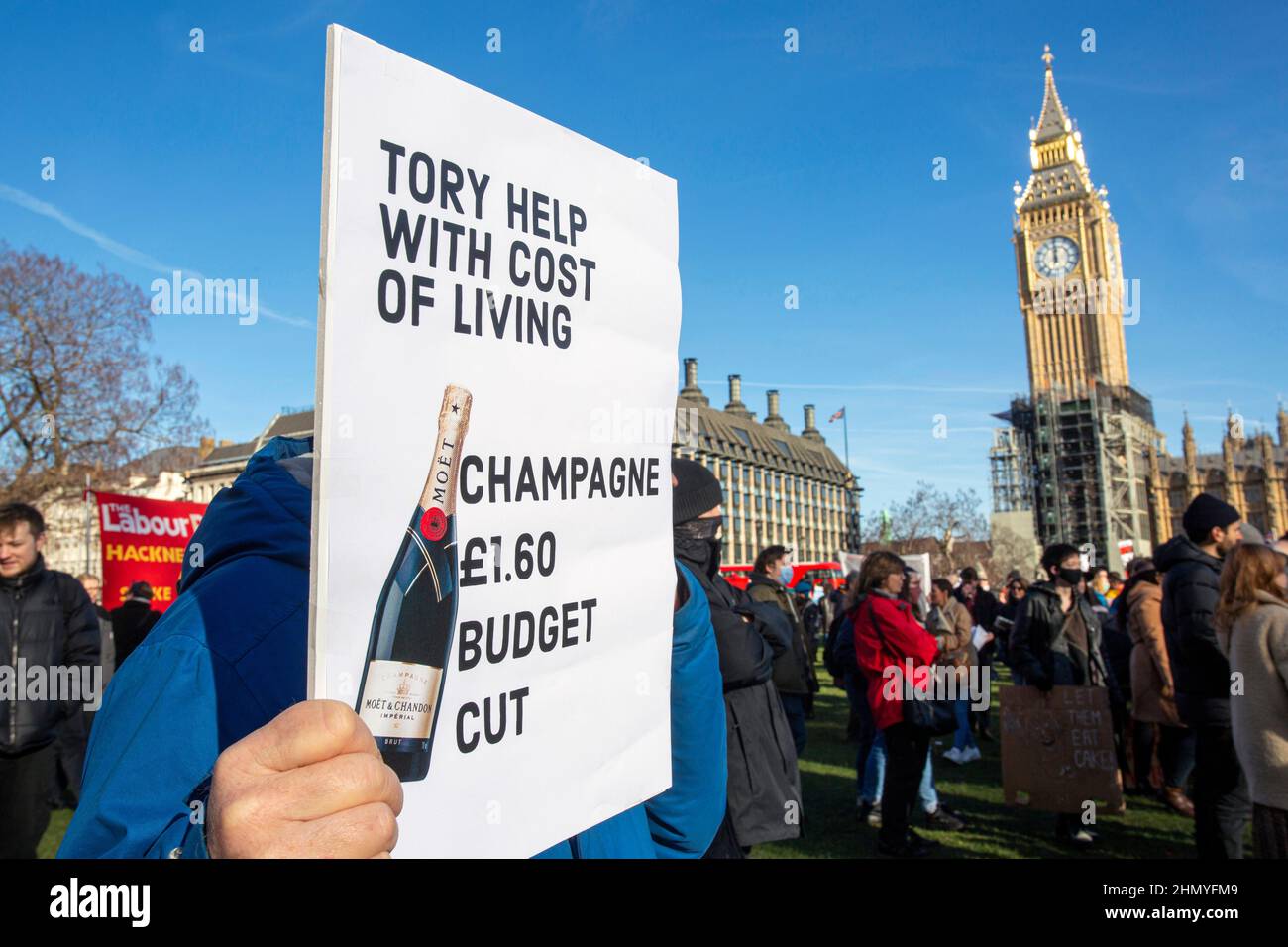 London, UK 12 th February 2022. Man holding sign 'Champagne budget cut 'Parliament Square in protest against the rises in fuel prices and costs of liv Stock Photo