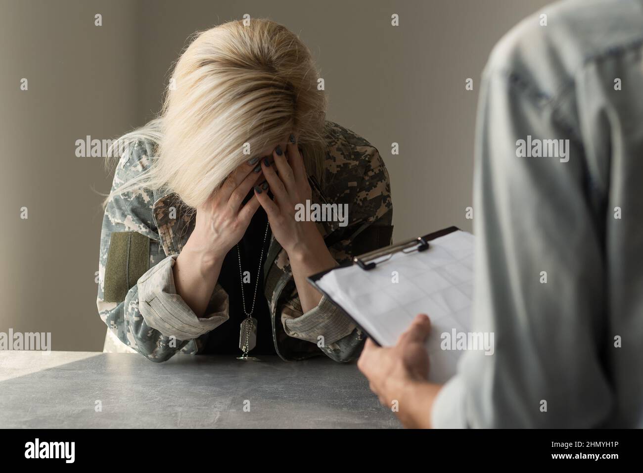 Patriotic military woman. Young patriotic military woman speaking with psychologist making notes Stock Photo