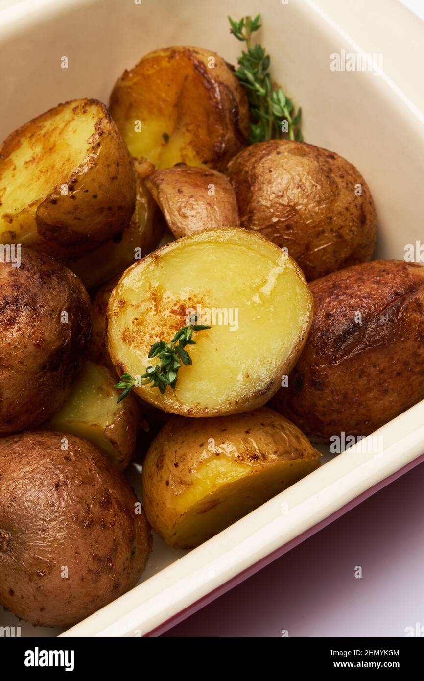 Baked potato in baking dish isolated on white background Stock Photo