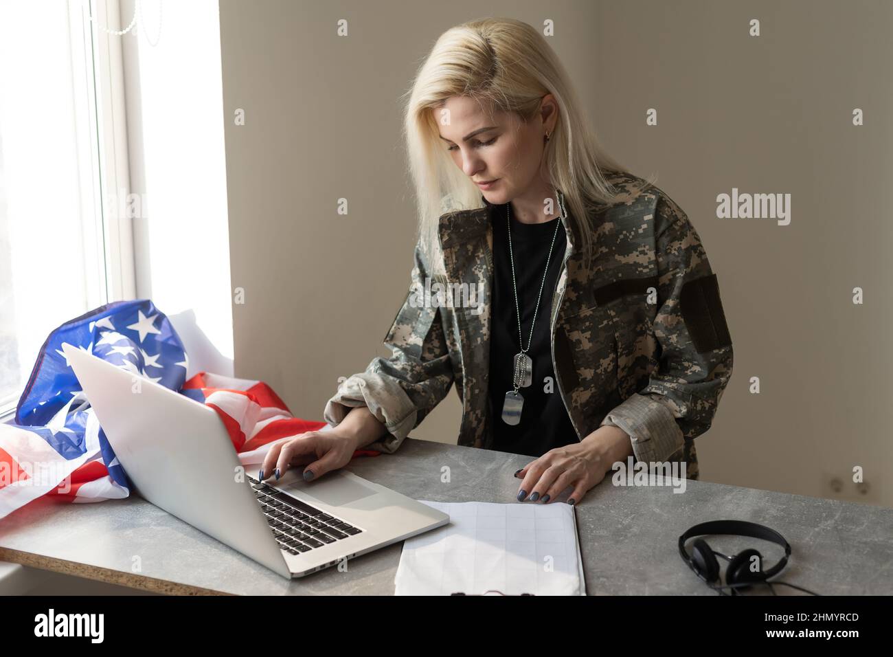 Young female soldier working with laptop in headquarters building Stock ...