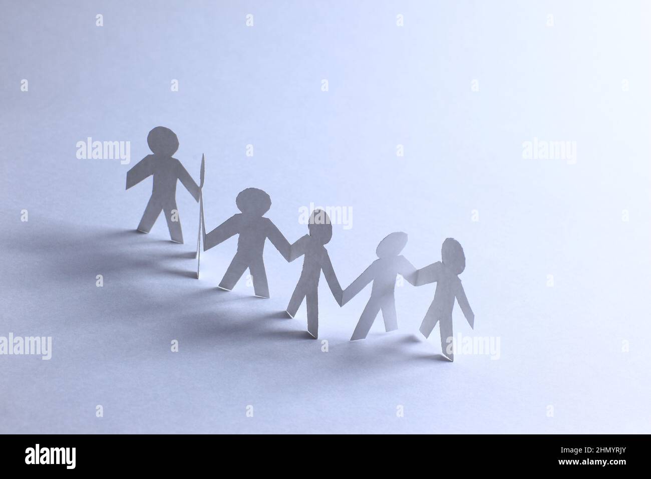 Team of paper doll people holding hands Stock Photo Alamy
