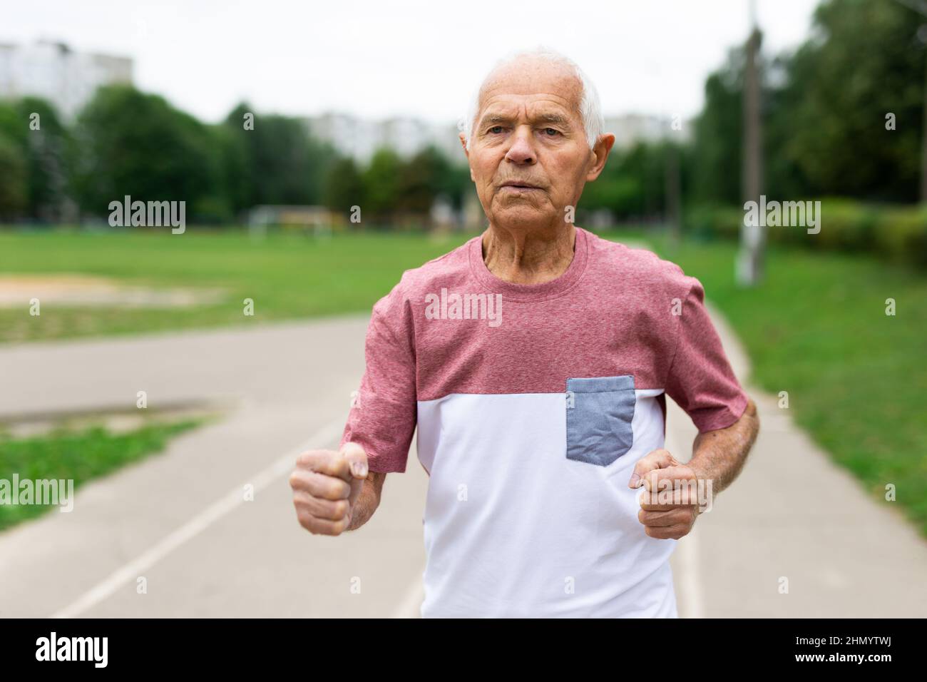 Old man running through city park in summertime Stock Photo - Alamy