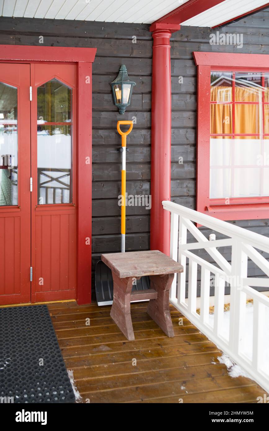 entrance of Storforsen church in Sweden with a snow shovel hanging at the wall Stock Photo
