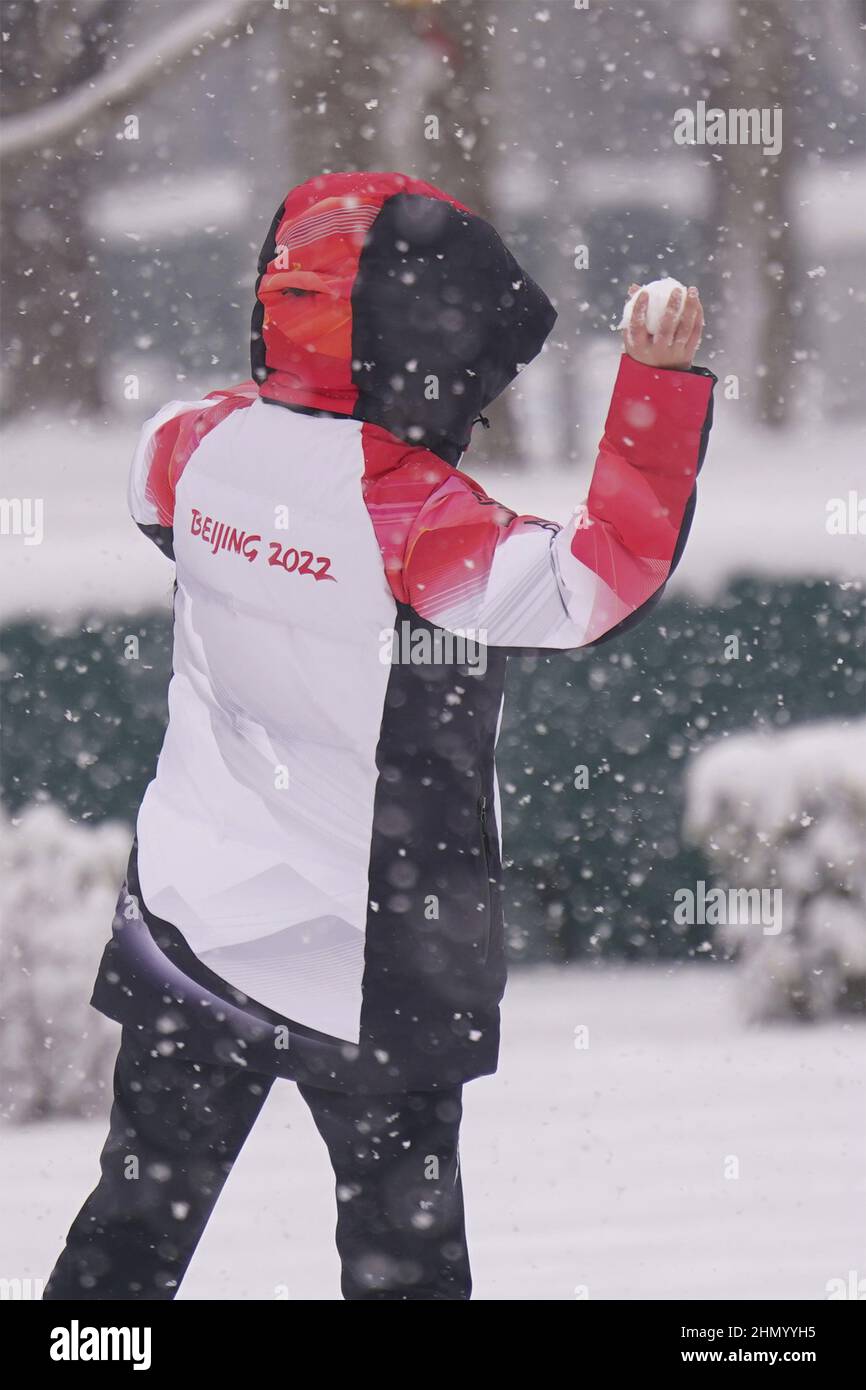 An Olympic volunteer throws a snowball during a heavy snowfall at the