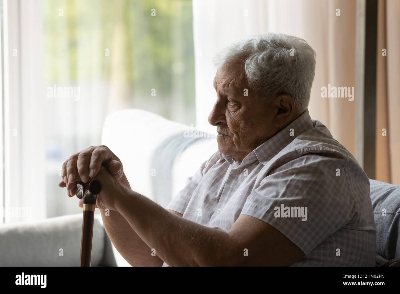 Sad depressed older 80s man holding gimp stick knob Stock Photo