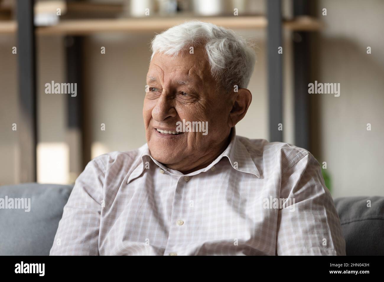 Positive pensive older 80s man looking away with good thoughts Stock Photo