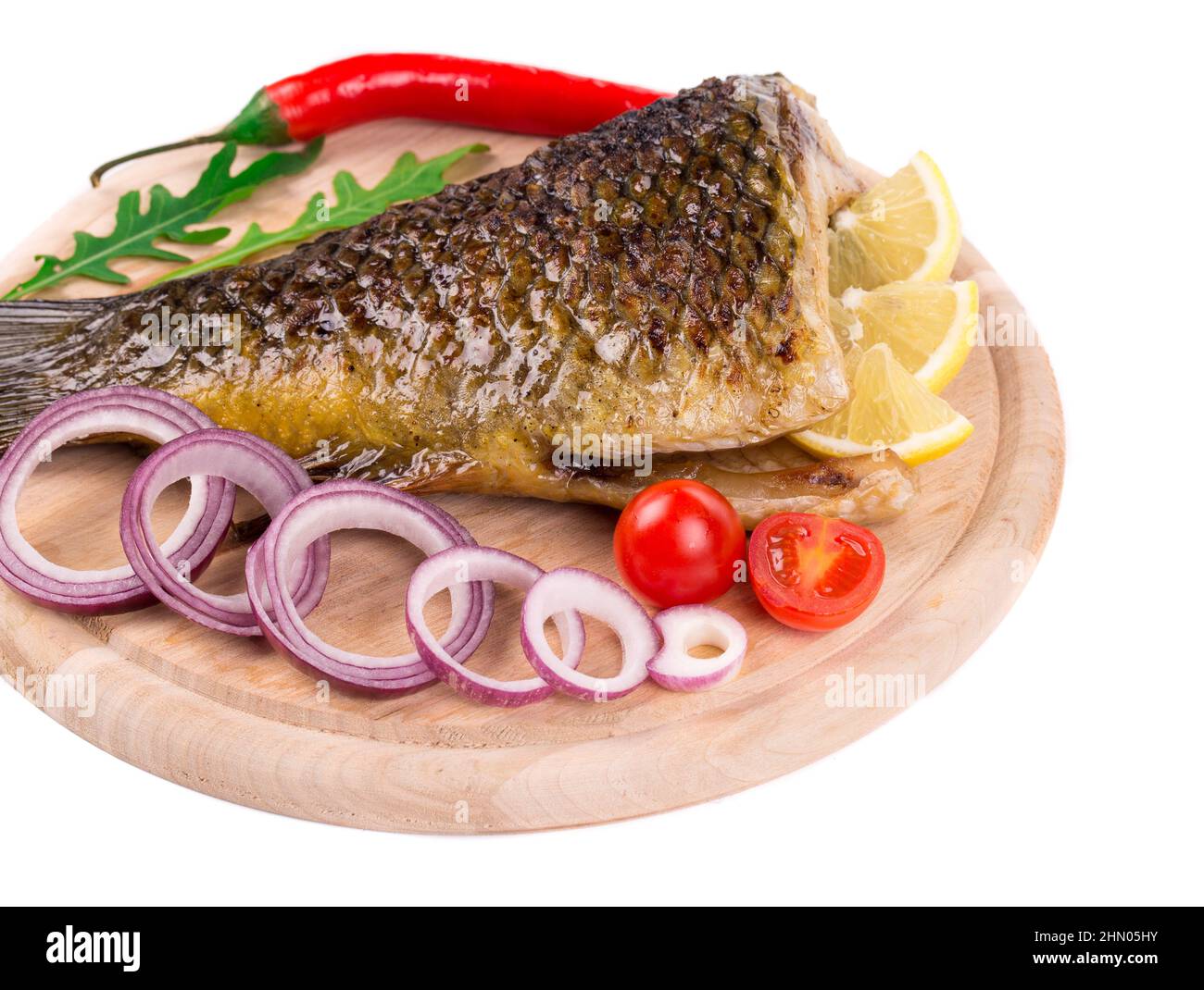 Fried carp tail with lemon and pepper. Isolated on a white background. Stock Photo