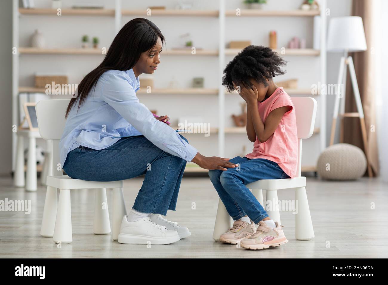 Distressed black kid crying at psychotherapy session Stock Photo
