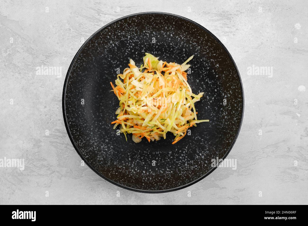 Pickled slices of cabbage and carrot on a plate, top view Stock Photo