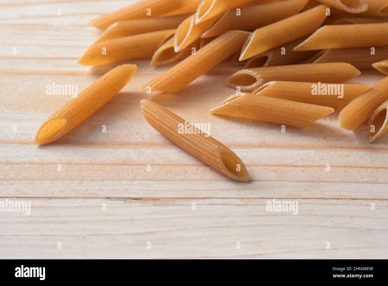 Wholegrain noodles, healthy pasta alternative with more fiber, minerals, protein and B vitamins, light wooden table, copy space, selected focus, very Stock Photo