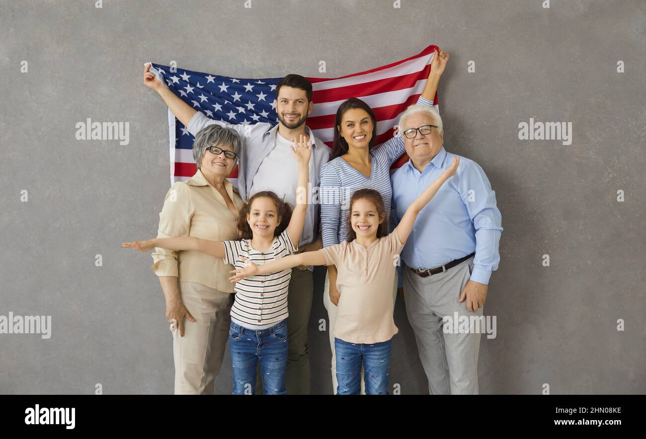 Portrait of happy three generations family with american flag on gray backg...
