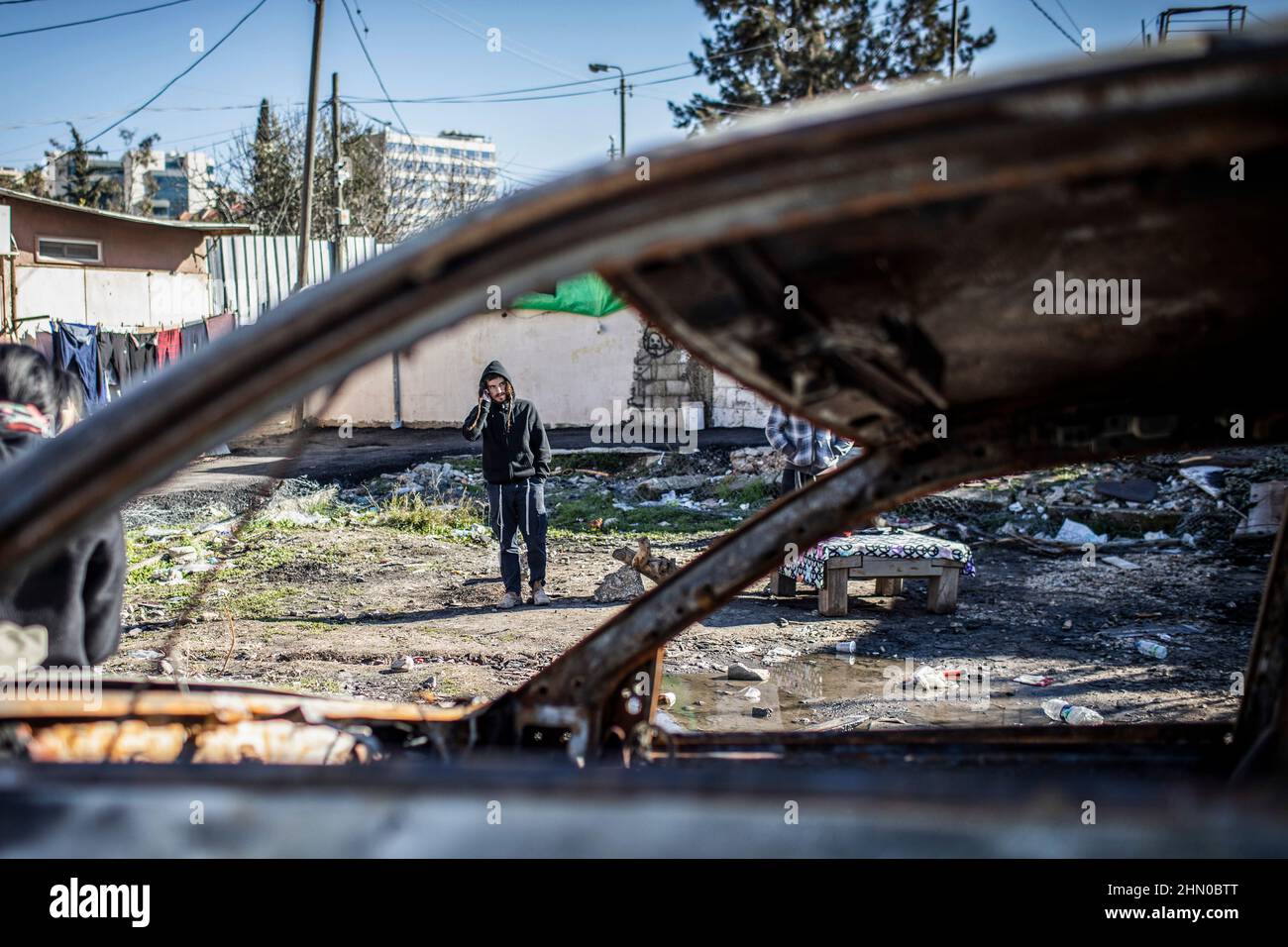 Jerusalem, Israel. 13th Feb, 2022. A Jewish settler is seen through the window of a burnt-out car in the neighbourhood of Sheikh Jarrah, where Israeli right-wing Knesset member Itamar Ben-Gvir arrived to open his parliamentary office in between the Jewish and the Muslim houses. Credit: Ilia Yefimovich/dpa/Alamy Live News Stock Photo