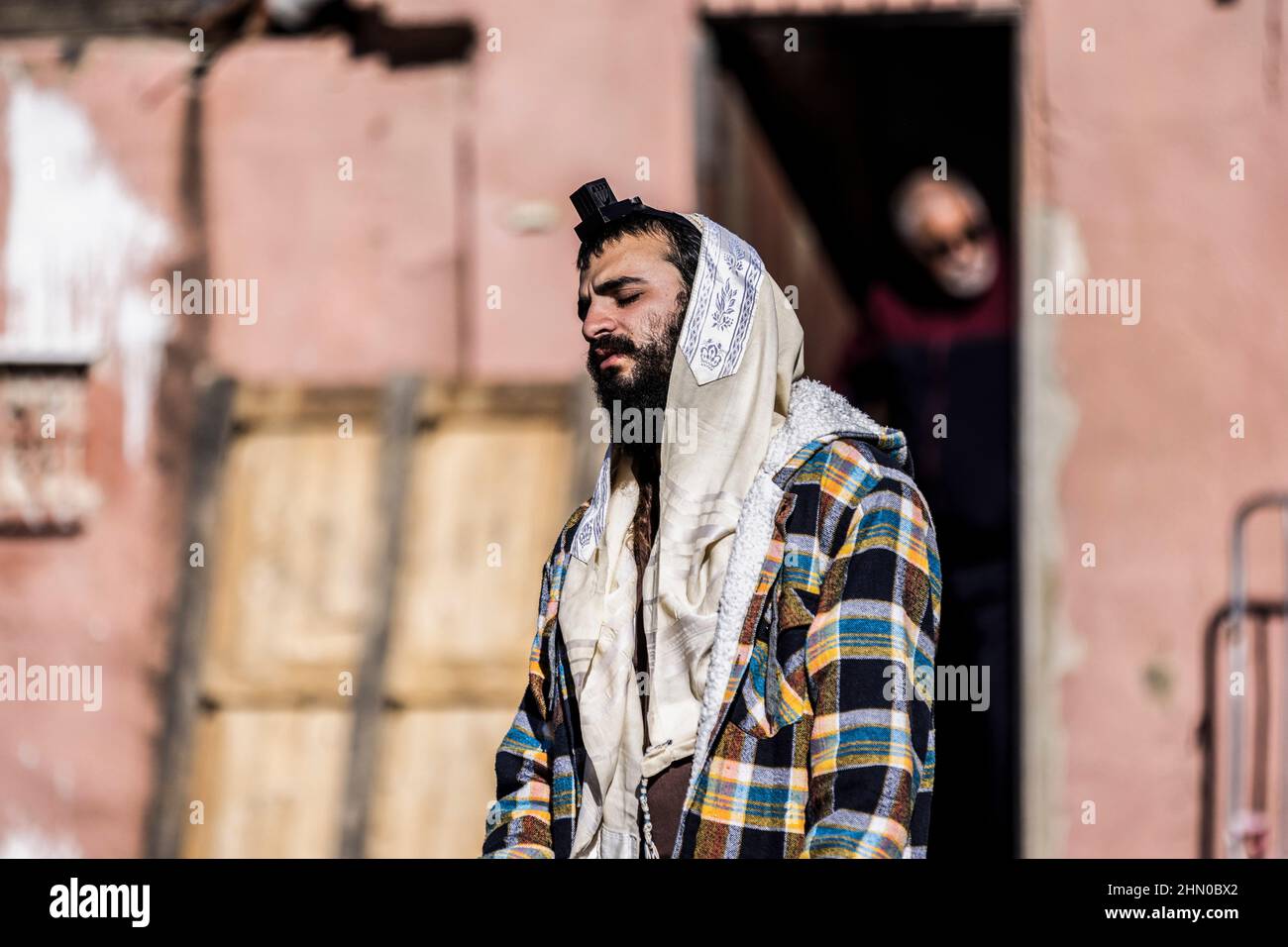 Jerusalem, Israel. 13th Feb, 2022. A Jewish settler wearing a Tefillin performs prayers in the neighbourhood of Sheikh Jarrah, where Israeli right-wing Knesset member Itamar Ben-Gvir arrived to open his parliamentary office in between the Jewish and the Muslim houses. Credit: Ilia Yefimovich/dpa/Alamy Live News Stock Photo