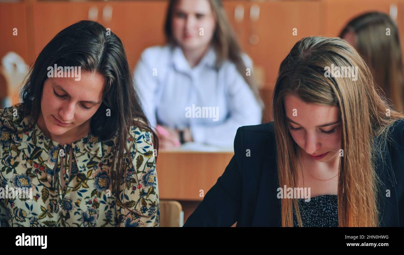 Pupils of the 11th grade in the class at the desks during the lesson. Russian school. Stock Photo