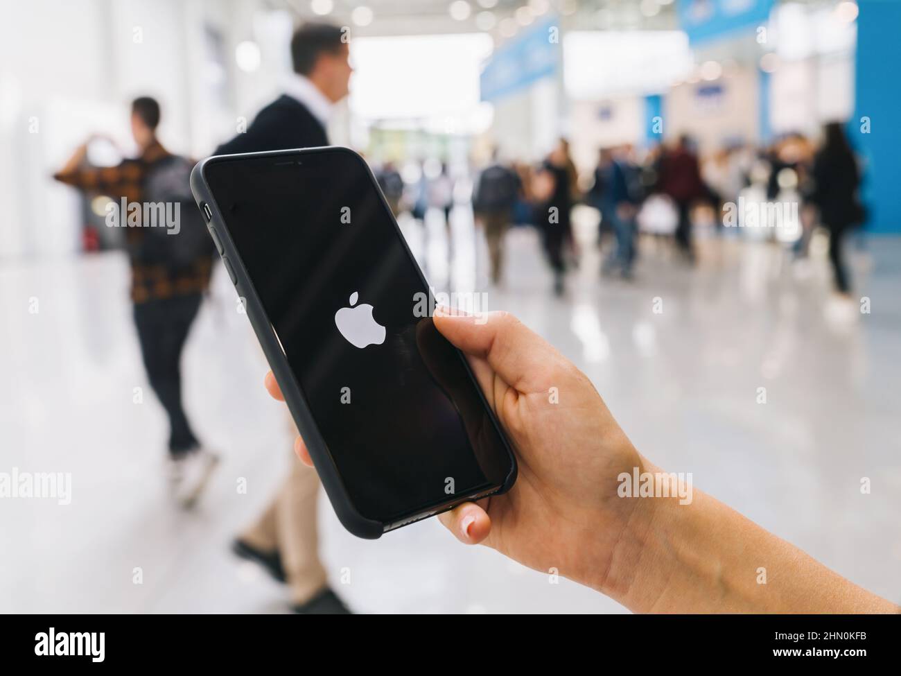 Woman hand holding iphone Xs with logo of apple, produced by Apple Computer, Inc. Stock Photo