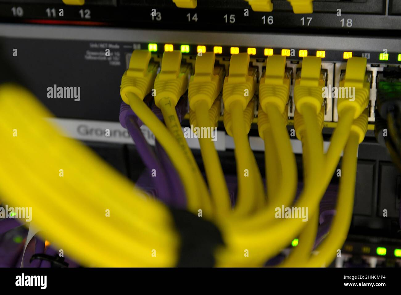 RJ45 yellow patch cables in the back of a data cabinet Stock Photo