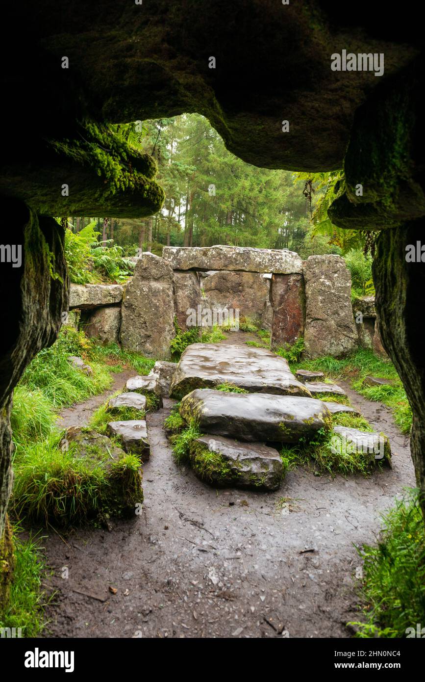 View out form an artificial cave towards an altar and standing stones at the Druids Temple, a folly at Ilton near Masham, North Yorkshire Stock Photo