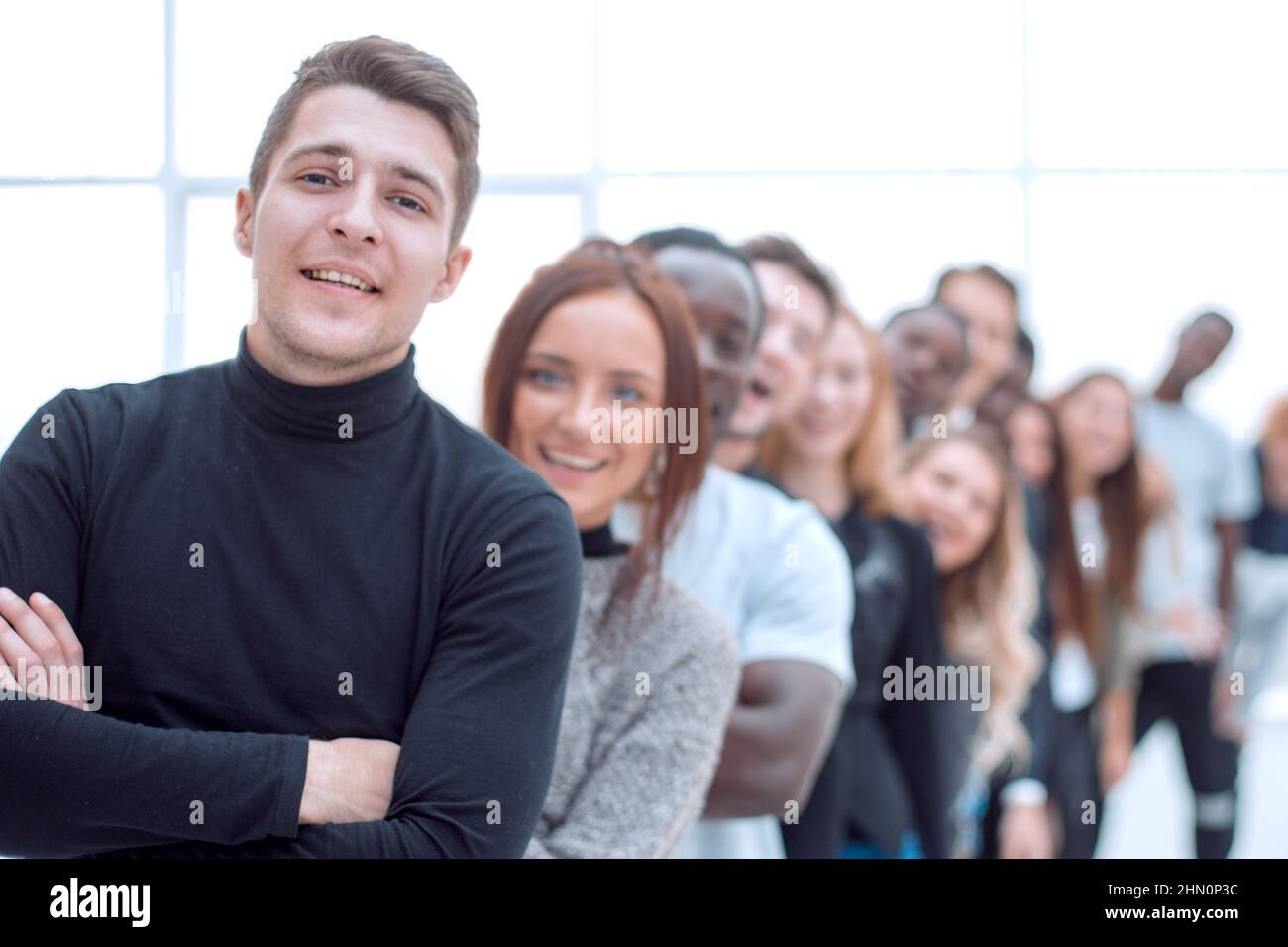 young man standing in front of a group of young people Stock Photo - Alamy