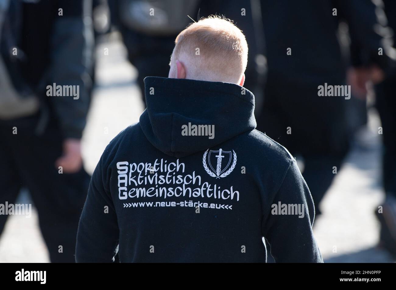 Dresden, Germany. 13th Feb, 2022. A participant of a rally of neo-Nazis wears a sweater with the inscription 'Sportlich Aktivistisch Gemeinschaftlich'. The procession, declared as a silent march, was accompanied by several counter-demonstrations. Credit: Sebastian Kahnert/dpa-Zentralbild/dpa/Alamy Live News Stock Photo