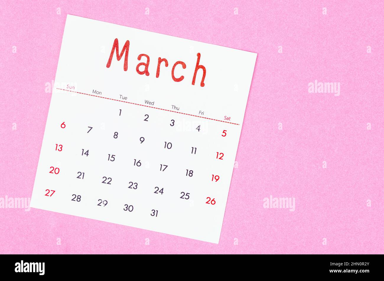The March 2022 calendar on pink background with empty space. Stock Photo
