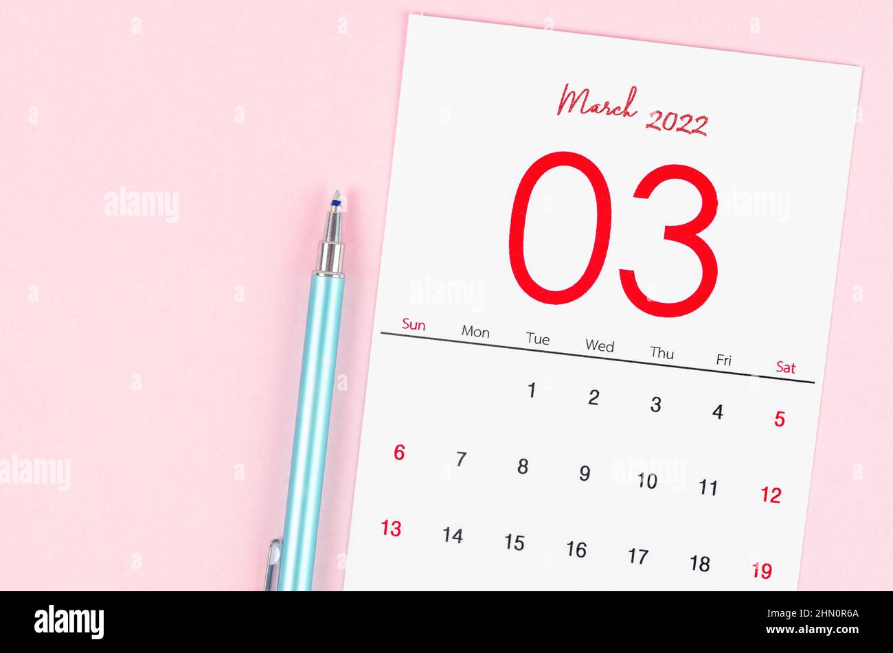 The March 2022 calendar with pen on pink background. Stock Photo