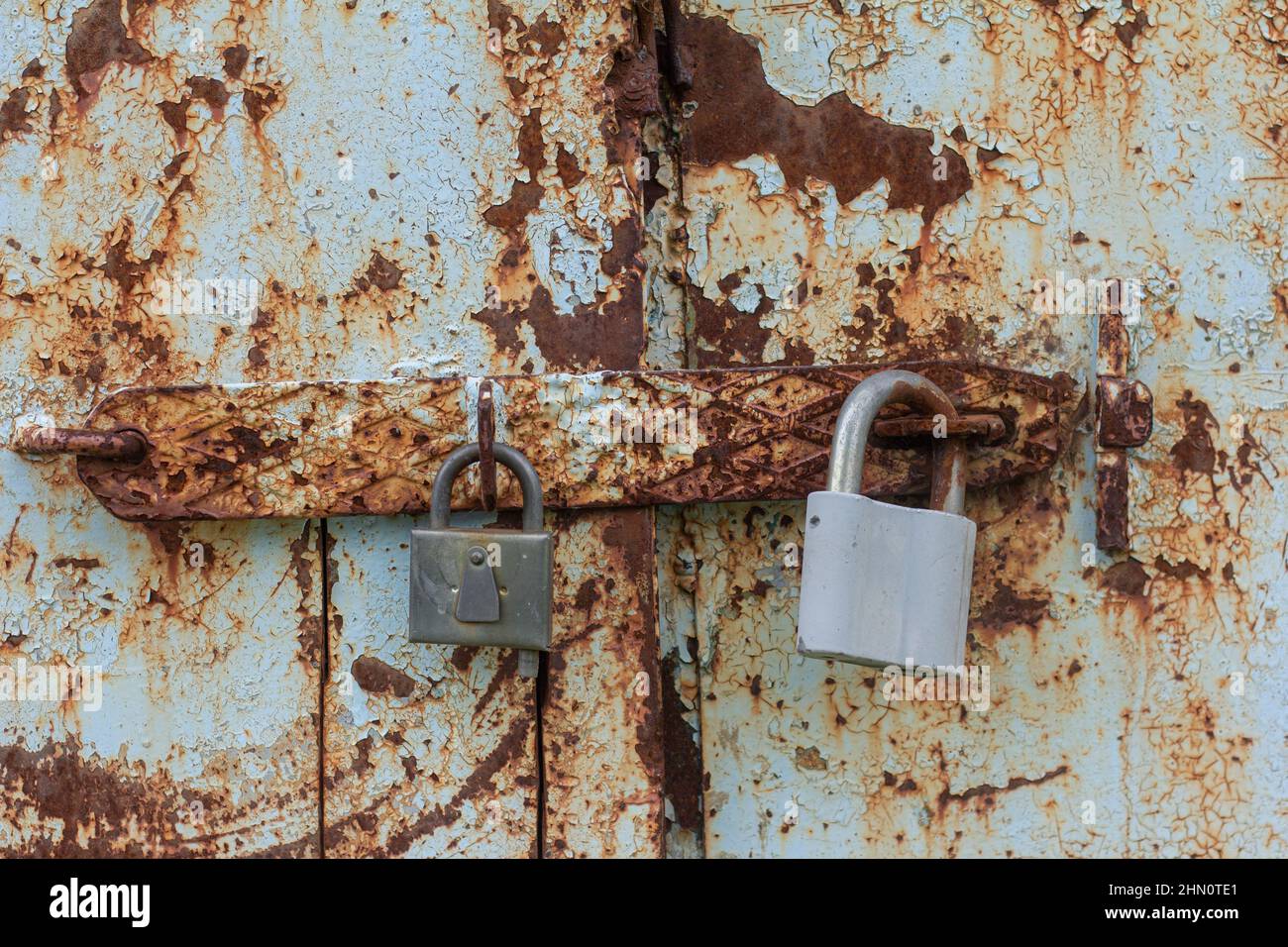 Two padlocks on a rusty metal door Stock Photo