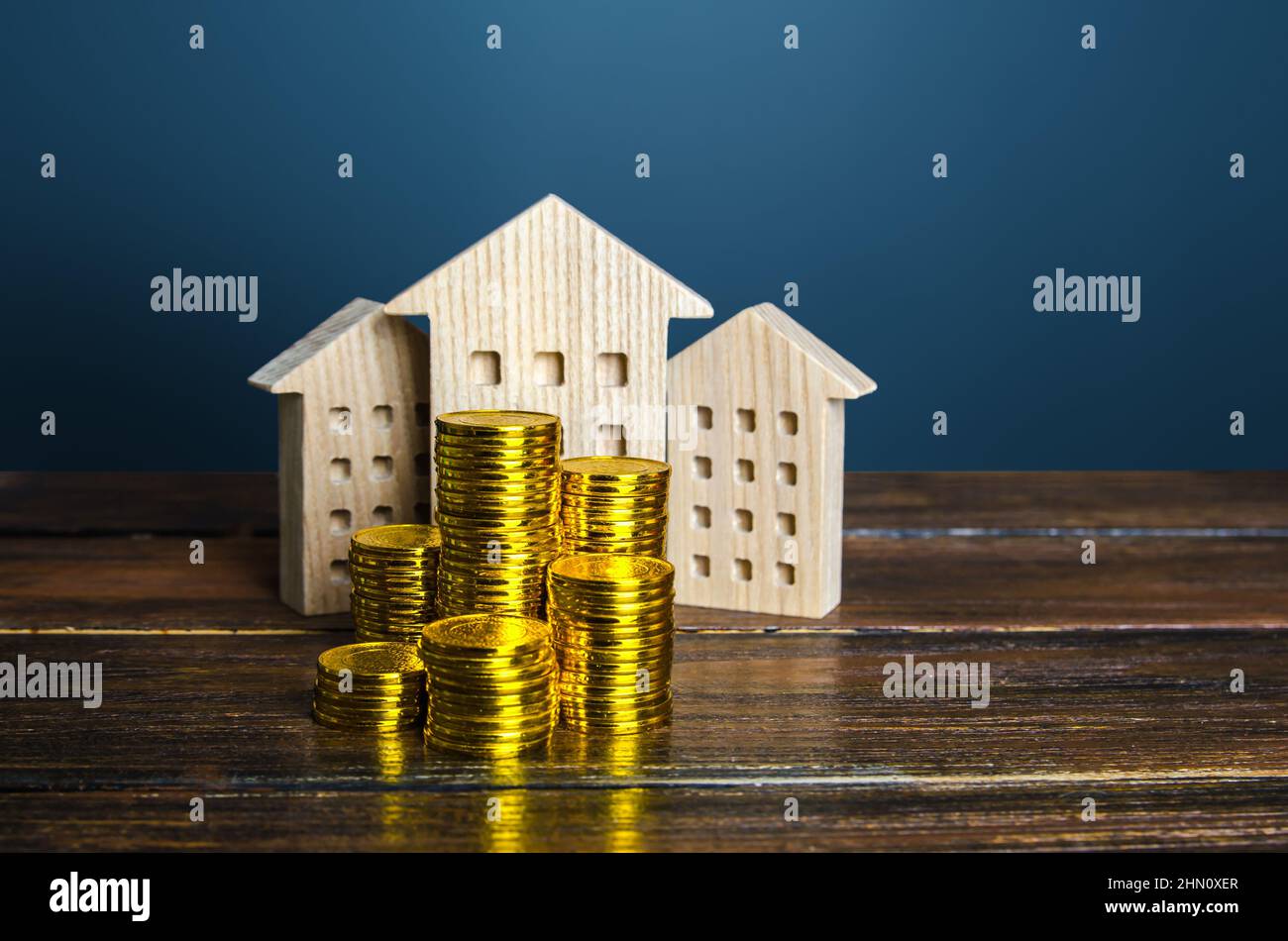 Residential buildings and coins stacks. Municipal budgeting. Tax collection, investments in city development. Profitability of rental business. Valuat Stock Photo