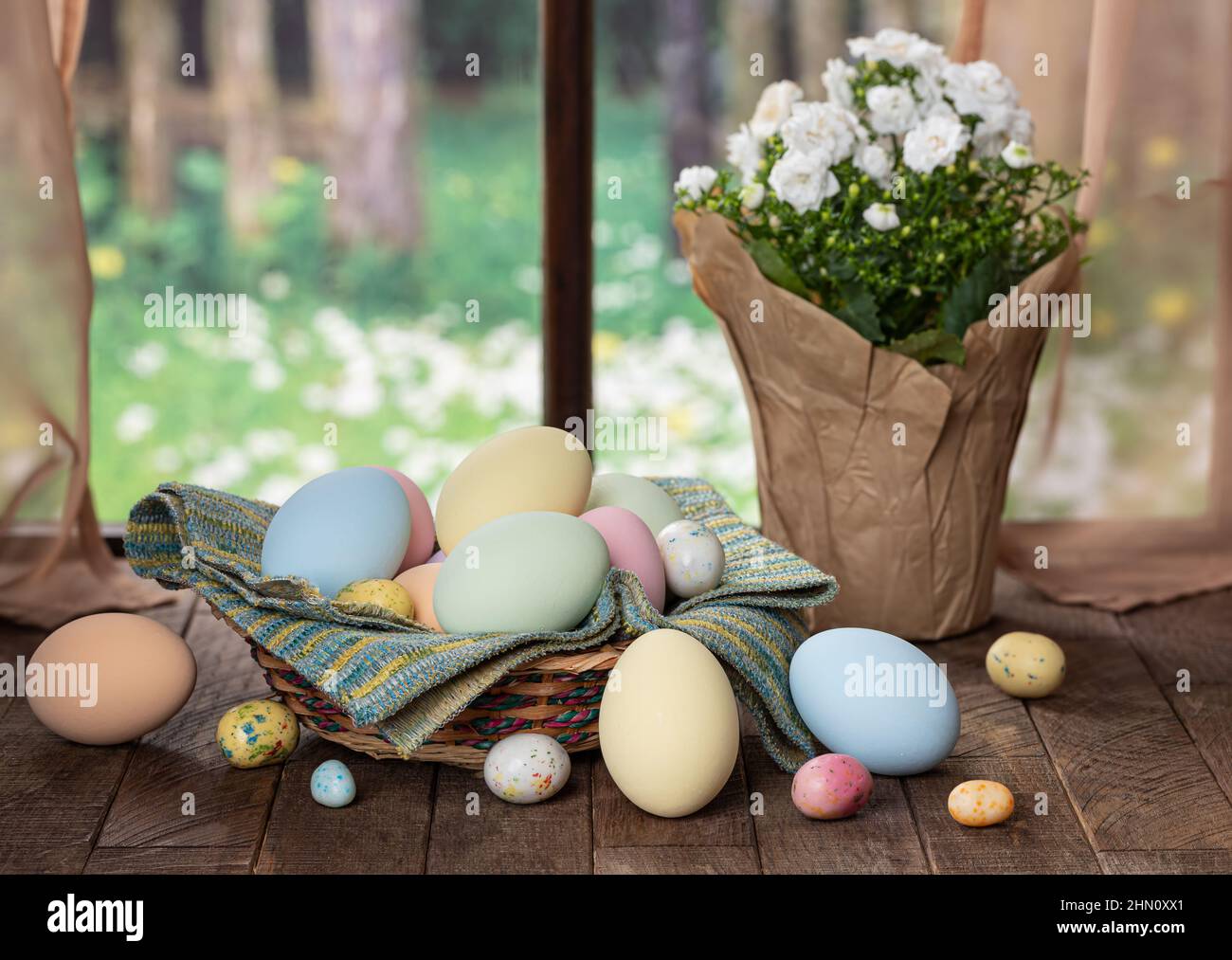 Colorful easter eggs in a basket and on a rustic wooden table and a ...