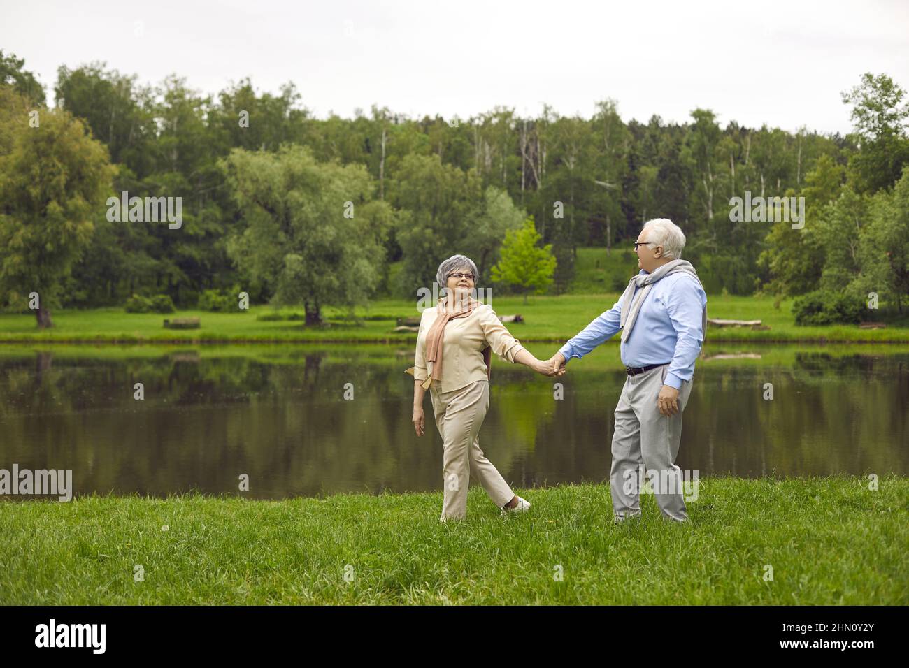 Senior man and woman holding hands in the park Stock Photo