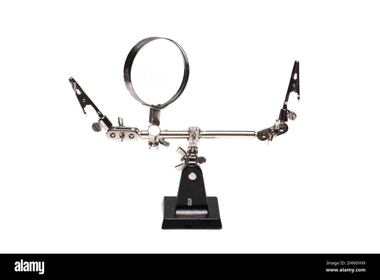 Close up of auxiliary tool as stand with clamps to hold various objects while working with magnifying glass called third or helping hand on white back Stock Photo