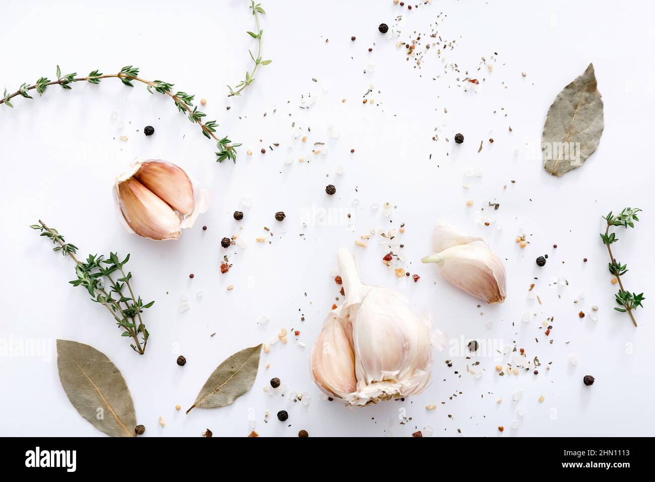 Different spices and garlic on light grey background, top view. Stock Photo