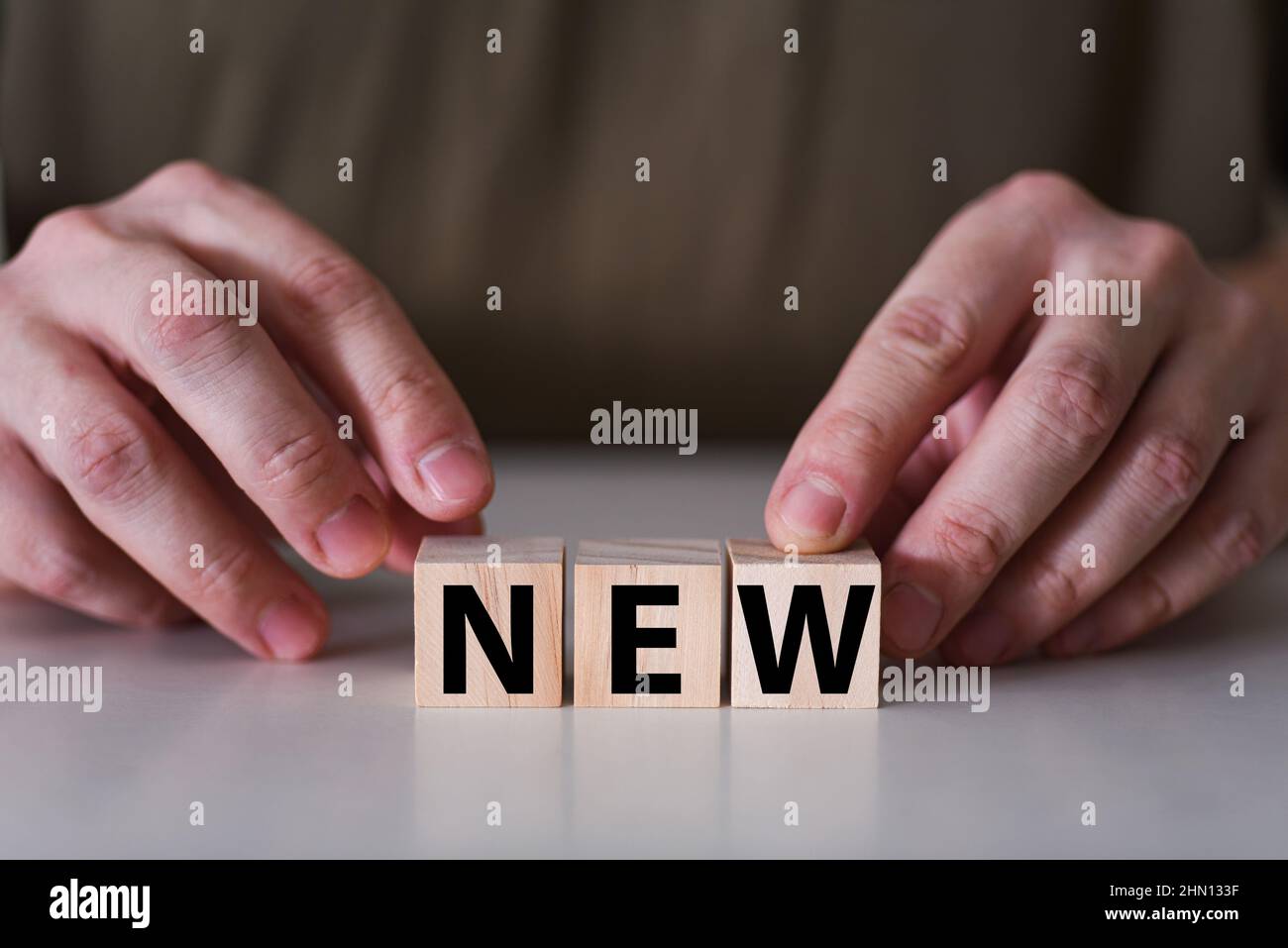 Businessman holding wooden cubes with new word. Small and medium business start up concept. Stock Photo